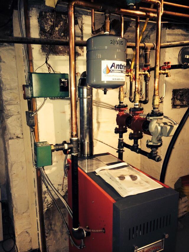 A premier gas furnace in a room with Antrim Plumbing pipes for efficient boiler repair, Boiler Repair Services in The Delaware County, PA