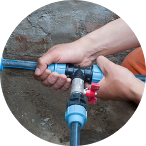 A man doing repairs on a busted underground water line