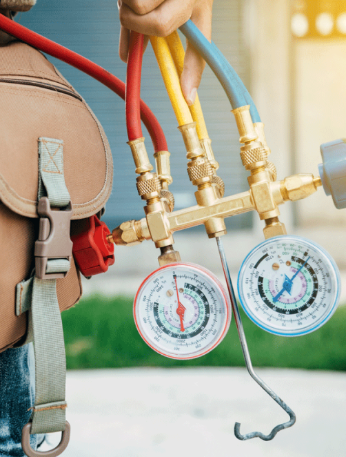 A man holding a set of gauges and a backpack, providing Antrim Plumbing's Air Conditioning Tune-Up Services in Delaware County.