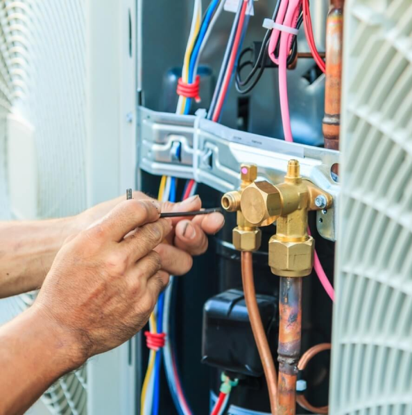 A man doing maintenance work on a heating device., Heating Maintenance Services in Delaware County, PA